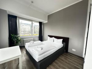 Schlafzimmer mit einem Bett mit weißer Bettwäsche und einem Fenster in der Unterkunft Ootel.com in Berlin