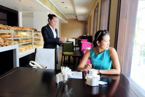 two women sitting at a table in a restaurant at Arunreas Hotel in Phnom Penh