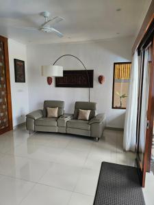 ein Wohnzimmer mit einem Sofa in der Mitte in der Unterkunft Welcome to Serenity Villa. in Munggu