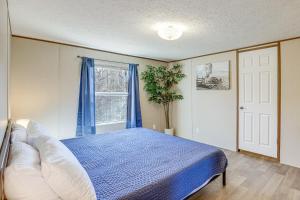 een slaapkamer met een blauw bed en een raam bij Pet-Friendly Home about 5 Mi to Blue Ridge Parkway! in Asheville