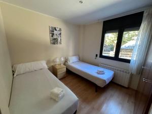 a small room with two beds and a window at Apartament La Solana del Tarter 5p - El Tarter - Zona Grandvalira in Sant Pere