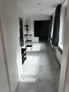 a hallway with white marble flooring and a chair at Rauf und Justyna 2 in Scharmbeck