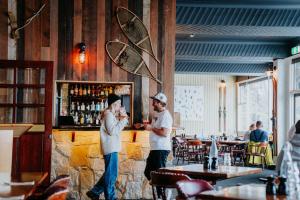 two men standing at a bar in a restaurant at Falls Creek Hotel in Falls Creek