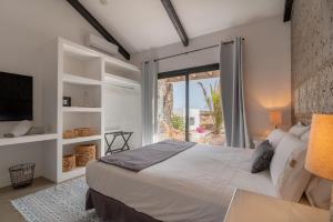 a bedroom with a large bed and a large window at Villa Shepherd Lajares - LUXURY VILLA FUERTEVENTURA in Lajares