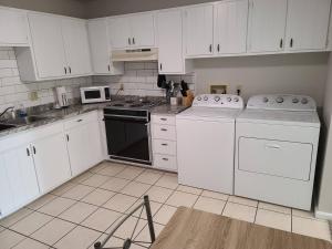 a kitchen with white cabinets and white appliances at The Oasis - C in Clovis