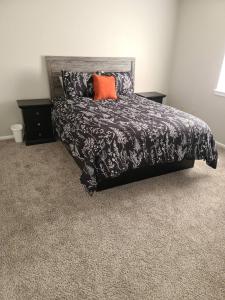 a bedroom with a black bed with an orange pillow at The Oasis - C in Clovis