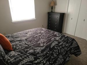 a bedroom with a bed with a black and white blanket at The Oasis - C in Clovis