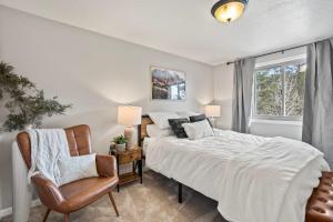 a bedroom with a bed and a chair and a window at Whispering Pines-Hot tub Getaway in Bailey