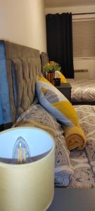 a bed with yellow and blue pillows on it at CityFlat Birmingham City B17 8 in Birmingham