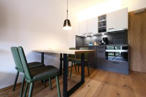 a kitchen with a table and chairs in a room at See-Apartments Kärntnerhof in Weissensee