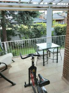 ein Fahrrad auf einer Terrasse mit Tisch und Stühlen geparkt in der Unterkunft SUKI HOUSE Chalet 1 in Madrid