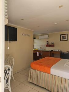 a hotel room with a bed and a kitchen at Maria Mulata Apartments in Noord