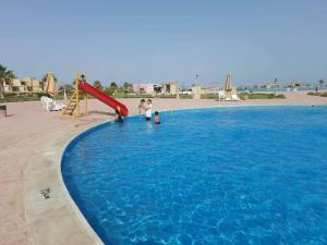 a group of people playing in a large swimming pool at Blumar El Sokhna Chalet in Ain Sokhna