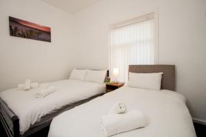 two beds sitting next to each other in a room at Metropolitan Charm: Stylish 2BR House in Manchester