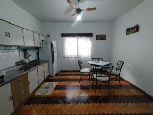 a kitchen with a table and chairs and a ceiling fan at Wollick Haus Quartos in Pomerode