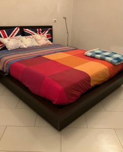 uma cama grande com um edredão colorido em Romantic Chic Loä em Loano
