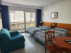 a room with two beds and a couch and a table at Apartamentos Leonor Carihuela in Torremolinos +50 photos