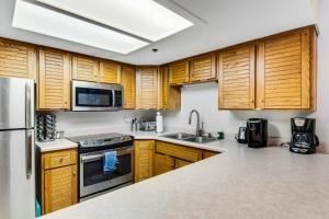 a kitchen with wooden cabinets and stainless steel appliances at Park Station #212 in Park City +21 photos