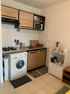 a kitchen with a washing machine and a stove at Le nid du Kikiwi , refuge relaxant avec jardin in Cayenne