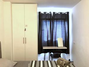um quarto com uma cama, uma secretária e uma janela em Apartamento de lujo en Torre del Sol, Playa de las Américas em Arona