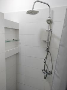 a shower with a shower head in a bathroom at Ker Vento in Rufisque