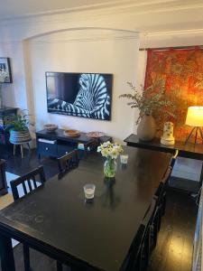 a living room with a table and a television at Spacious Flat in West Kensington in London