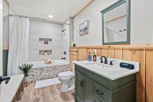 a bathroom with a sink and a tub and a toilet at Whispering Pines-Hot tub Getaway in Bailey +17 photos