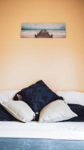 1 cama con 2 almohadas y una foto en la pared en apARTmanházak Miro ház, en Siófok
