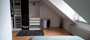 Cette chambre mansardée comprend un placard et un lit. dans l'établissement PRIVATE ROOM in a Shared Cozy Flat, à Düsseldorf