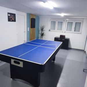a ping pong table in a room with at GM GÎTE maison neuve et tout confort in Lucey