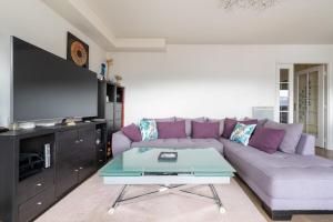een woonkamer met een bank en een tv bij Tranquil 3BD Flat w Chic PatioBNFOlympiades in Parijs