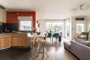 een keuken en een woonkamer met een bank en een tafel bij Tranquil 3BD Flat w Chic PatioBNFOlympiades in Parijs