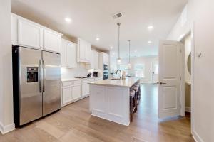 a kitchen with white cabinets and a stainless steel refrigerator at Coastal Club --- 33718 Freeport Dr. in Lewes