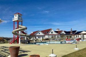 a playground with a clock tower next to a pool at Coastal Club --- 33718 Freeport Dr. in Lewes