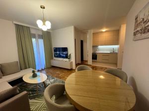 a living room with a wooden table and a couch at RS lux Becici in Becici