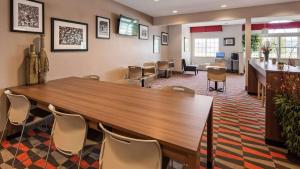 una sala de conferencias con una gran mesa de madera y sillas en Sonesta Essential Morgantown en Morgantown