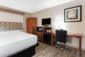 Habitación de hotel con cama, escritorio y TV. en Best Western U.S. Inn, en Nashville