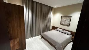 een slaapkamer met een bed en een groot raam bij M Residence - العبيكان هلز 3 in Riyad