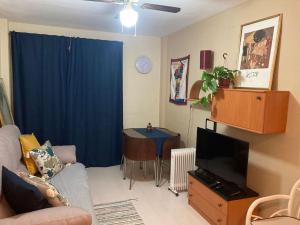 a living room with a couch and a tv and a table at Piso centro Salou cerca mar in Salou