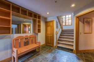 a home with a staircase and a wooden bench in a room at Aspen Ridge 32 - 2 bedroom townhouse in Telluride
