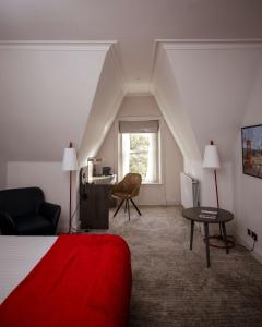 a hotel room with a red bed and a chair at JA The Bruntsfield - Edinburgh in Edinburgh +70 photos