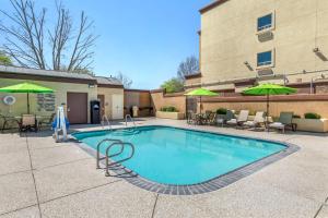 a pool with chairs and umbrellas next to a building at Best Western Plus Taft Inn in Taft