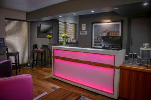 a bar with pink lighting in a barbershop at Heywood House Hotel, BW Signature Collection in Liverpool