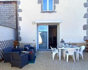 a patio with a white table and chairs at GITE TREFFLE A 4 FEUILLES in Le Mayet-de-Montagne