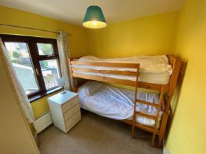 1 dormitorio con 2 literas y ventana en Kilbroney Rest en Rostrevor