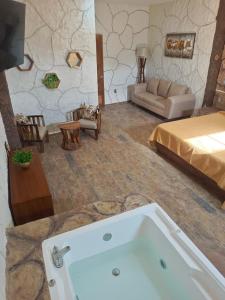 ein Bad mit einer Badewanne in einem Zimmer mit einem Bett in der Unterkunft Hotel Spa el Gran Coral By Rotamundos in Jocotepec