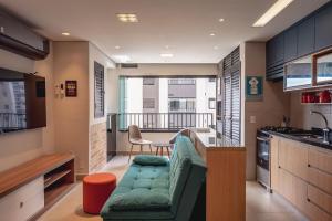 uma sala de estar com um sofá verde numa cozinha em Piscine Resort - Um Oasis no centro de SP | Canal do Anfitrião em São Paulo