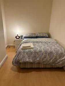 a bedroom with a bed with a blanket and a nightstand at Mortiara in Darlington