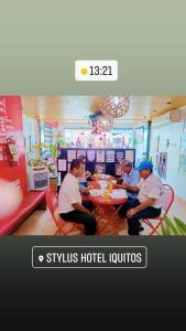 three men sitting at a table in a restaurant at Stylus Hotel in Iquitos