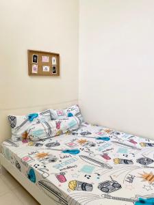 een bed met een dekbed en kussens erop bij RF Home - Home with 3 bedroom in Melaka